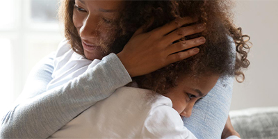 A daughter embracing her mom with a tight hug.